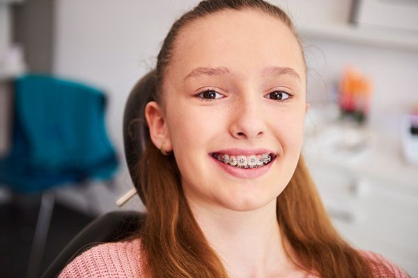  A smiling girl with braces, showcasing her progress in the Fixed Braces Patient Journey.