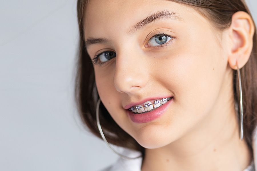 girl with braces, her head is tilted and she is wearing hoop earrings
